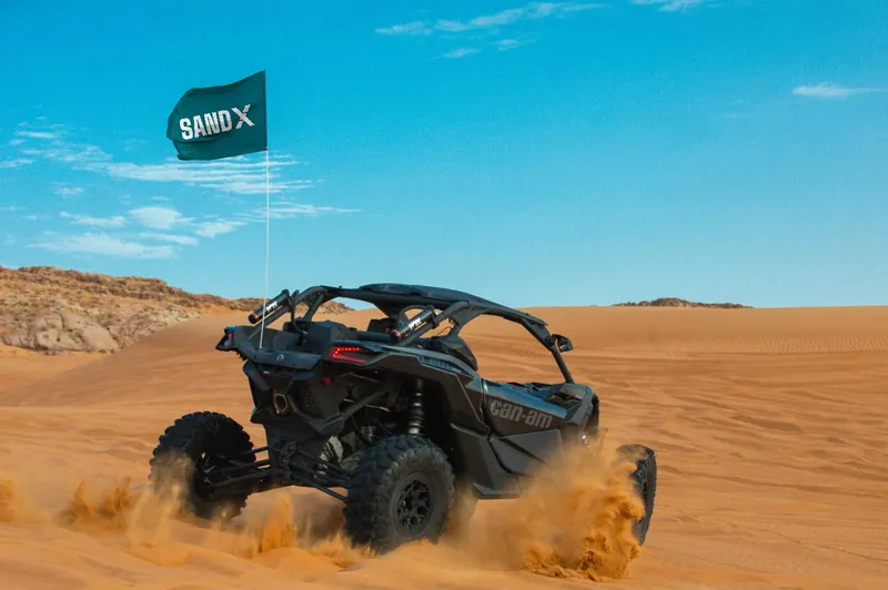 Can-Am Maverick X3 seen from behind spraying sand