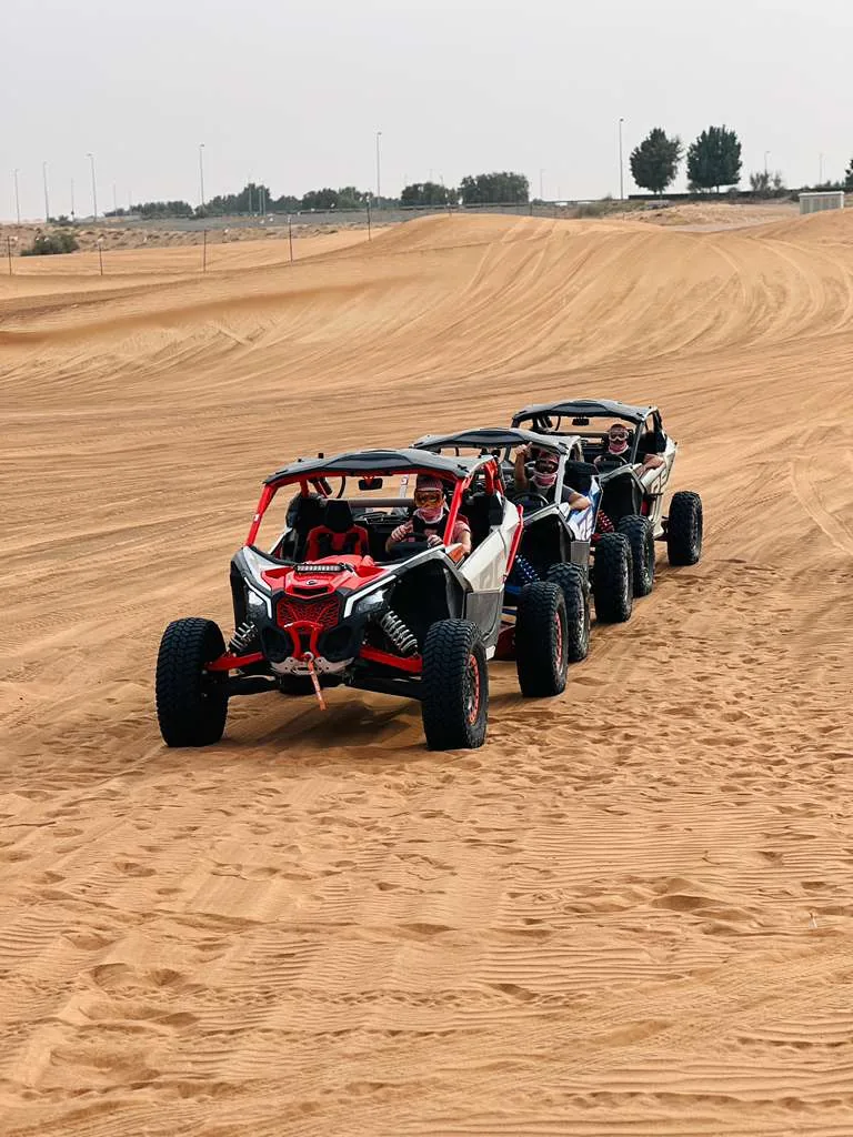 Can-Am Maverick X3 Turbo RR buggies driving in a line across the dunes