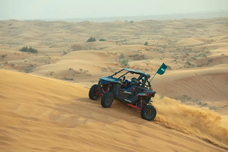 Polaris RZR RS1 driving across a dune slope