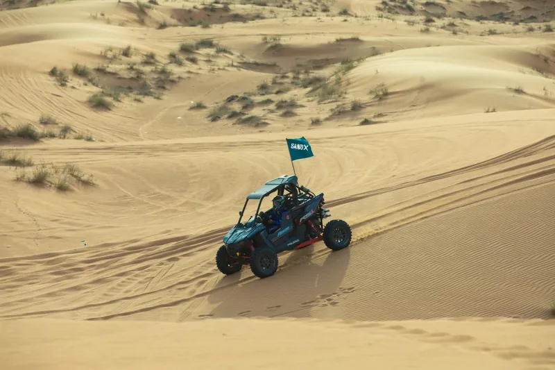 Polaris RZR RS1 crossing a pale dune slope