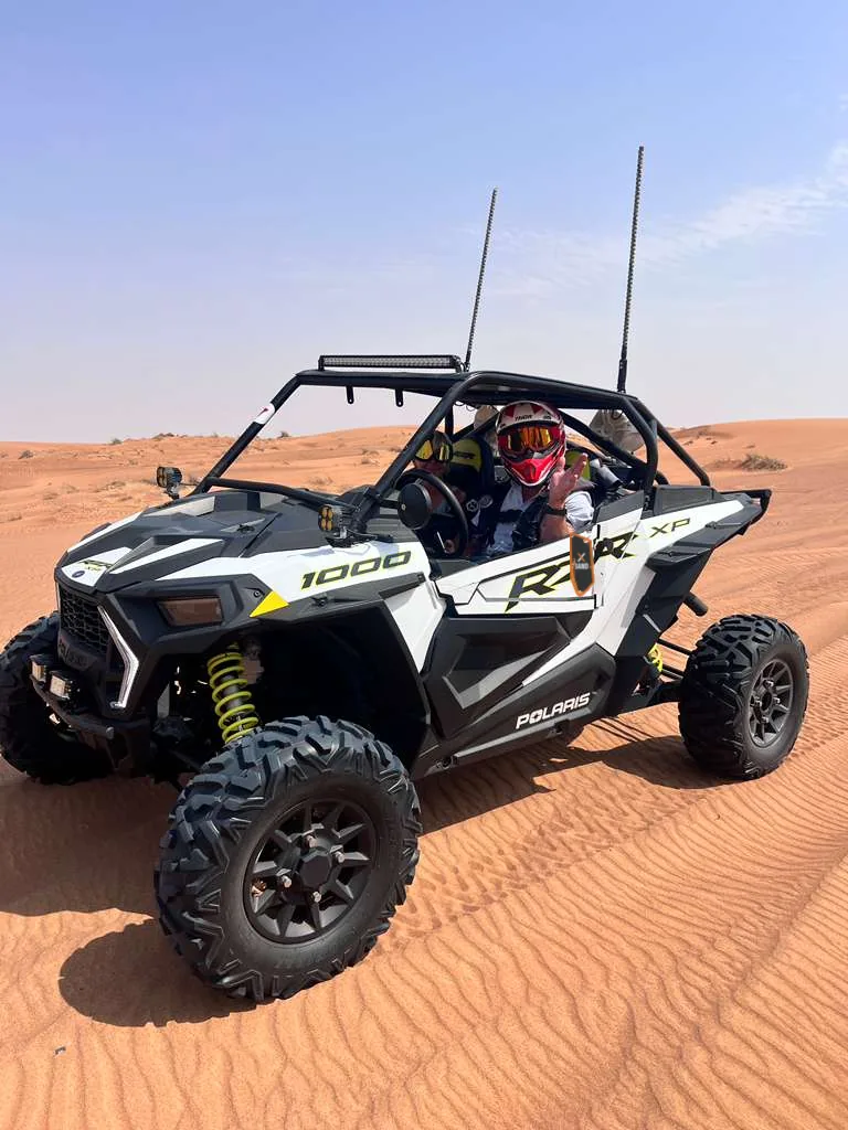 Driver at the wheel of a Polaris RZR XP 1000 in the desert