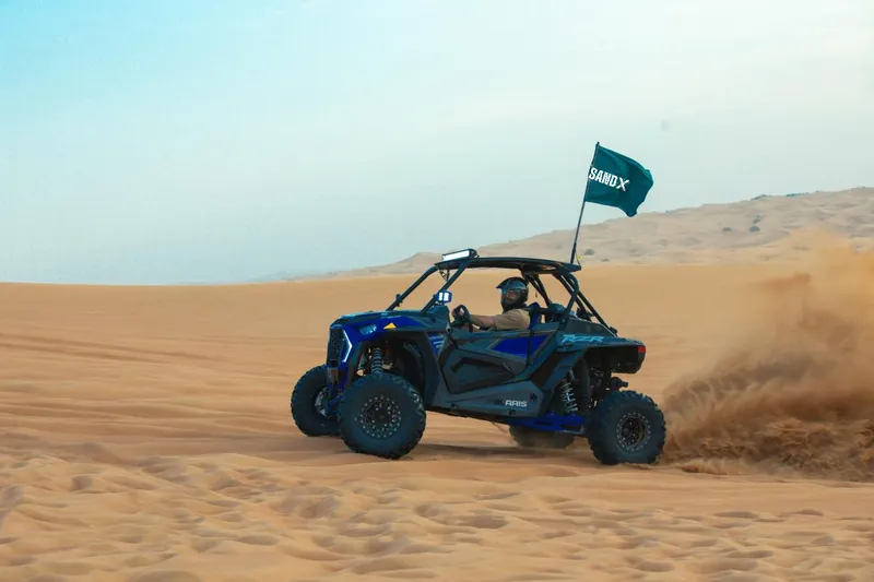Polaris RZR Turbo S driving with sand spraying behind